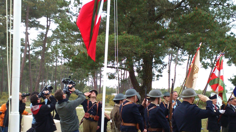 Izada de la ikurriña en el memorial de la Cota 40 en Montalivet ante el Lehendakari, el presidente de Aquitania y resto de autoridades durante los actos de homenaje del Gobierno Vasco a los gudaris del batallón Gernika en el 70ª Aniversario de la batalla de la Pointe de Grave (18 de abril de 1945)